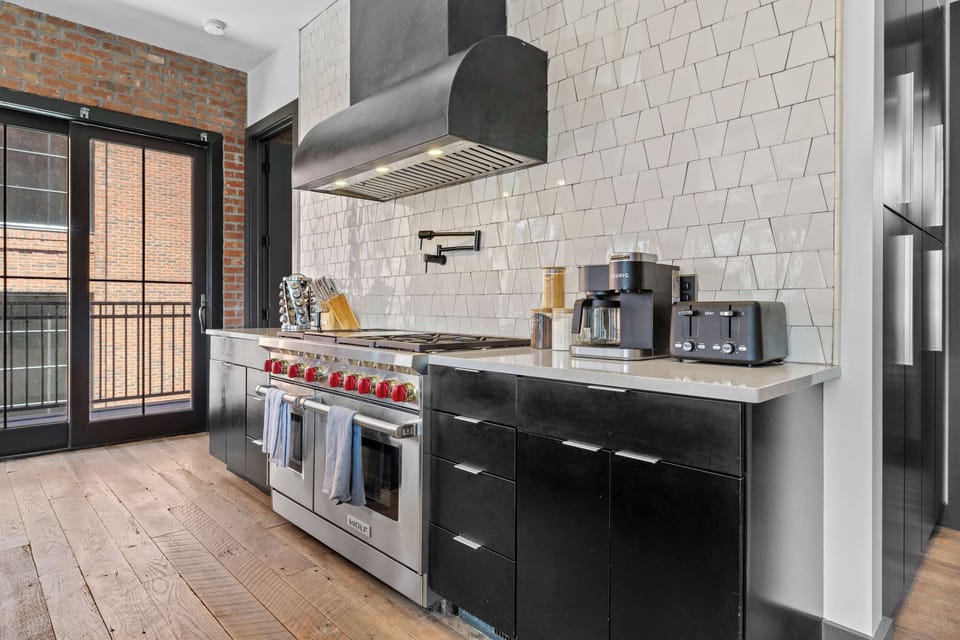 Spacious, fully equipped kitchen featuring a large island with bar seating, stainless steel appliances, coffee station, and plenty of counter space for preparing meals together.
