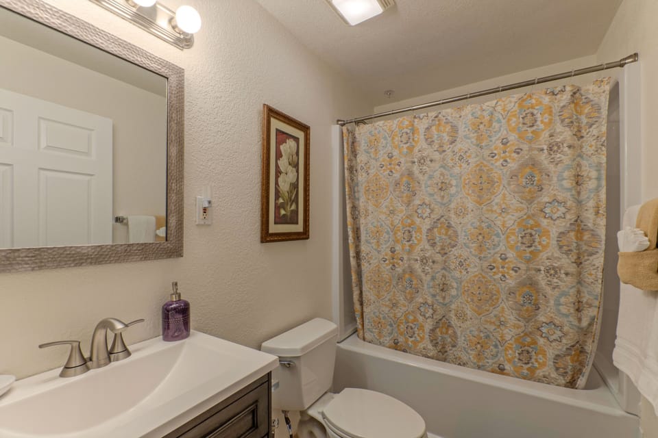 The south wing primary bedroom has a tub-shower combo in the en suite bath.