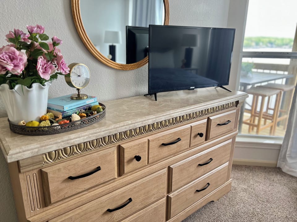 Master bedroom with large dresser, smart TV and view of the lake