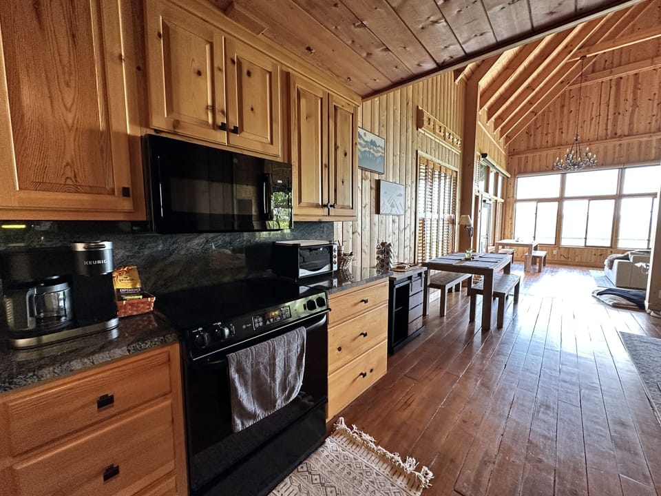 Kitchen equipped with stove, microwave, dishwasher, Keurig, and toaster oven.