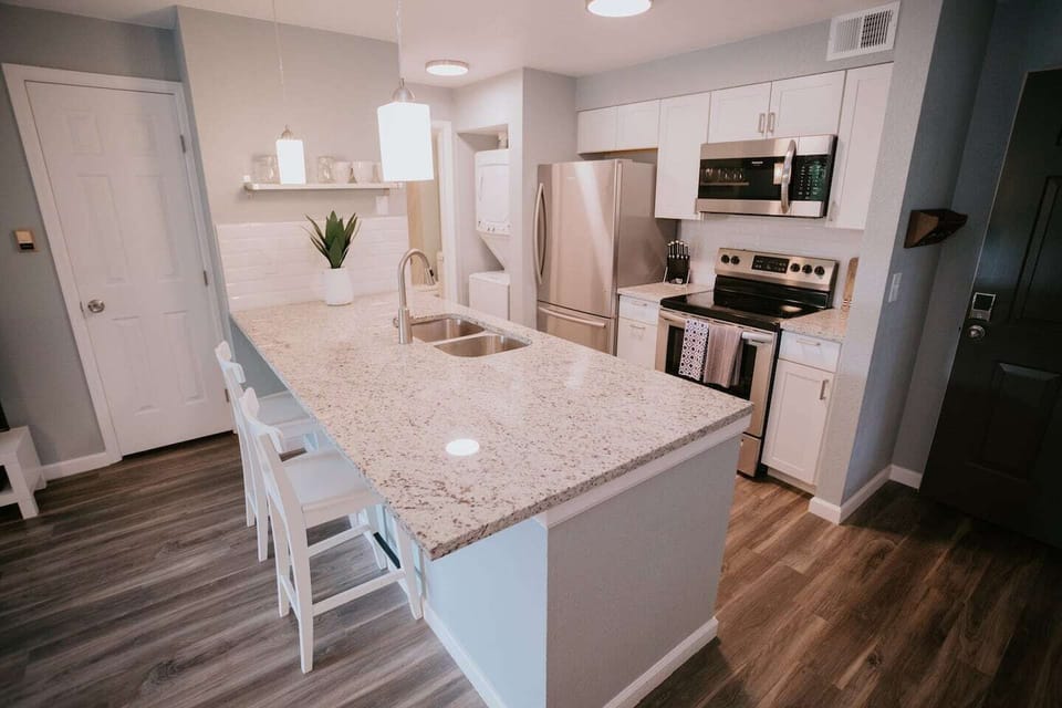 Granite counter tops, stainless steel appliances, and a well equipped kitchen