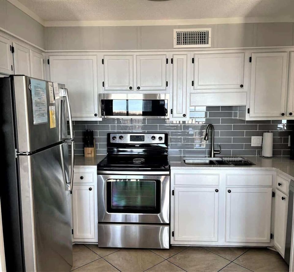 A clean, updated kitchen equipped with full-sized stainless steel appliances.