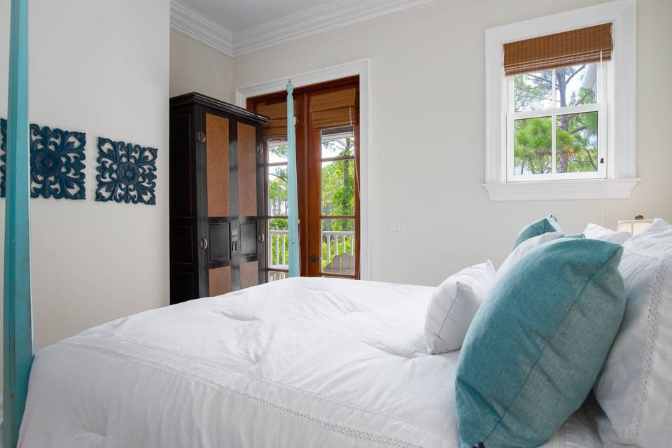 2nd floor bedroom with queen bed and doors to patio