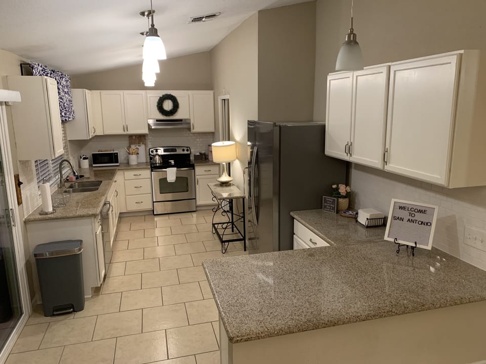Cabinets stocked with high quality pots, pans, dishes, cooking and baking. 