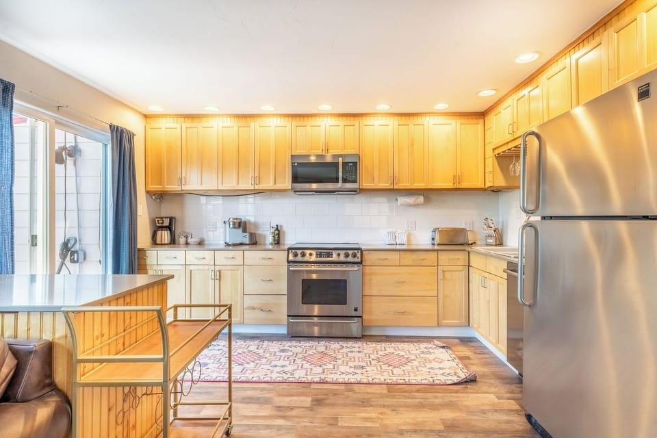 Full size kitchen with stainless steel appliances and granite countertops.