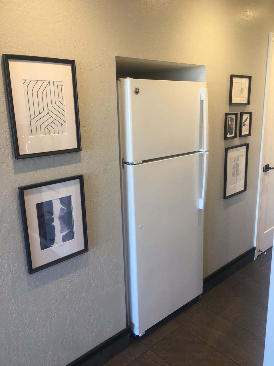 Full refrigerator in hall, just beside alley style kitchen