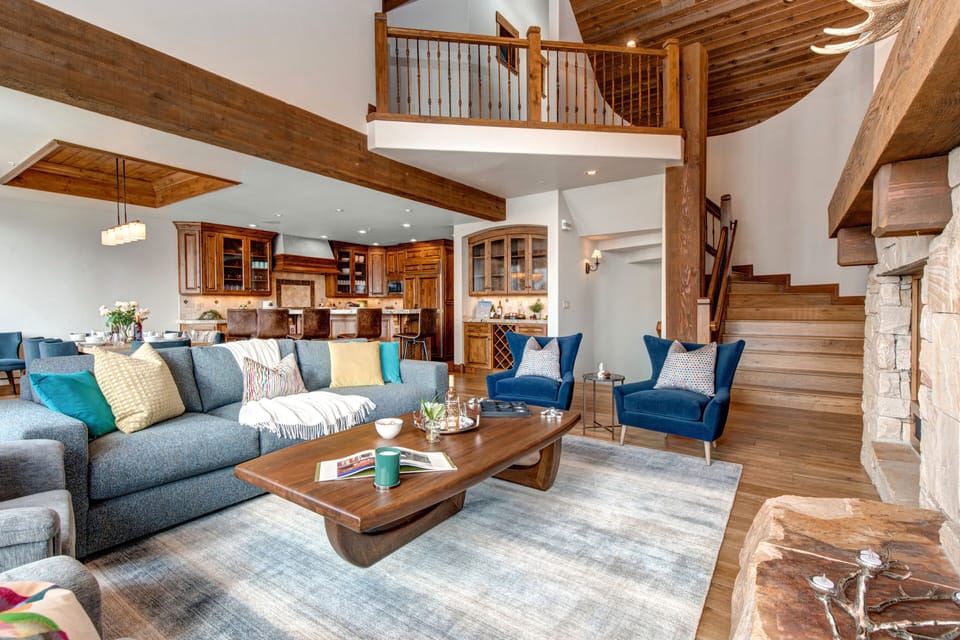 Living Room with plush furnishings, four armchairs, gas-assist fireplace, smart TV, wet bar, vaulted ceilings, and windows offering natural light and golf course views.