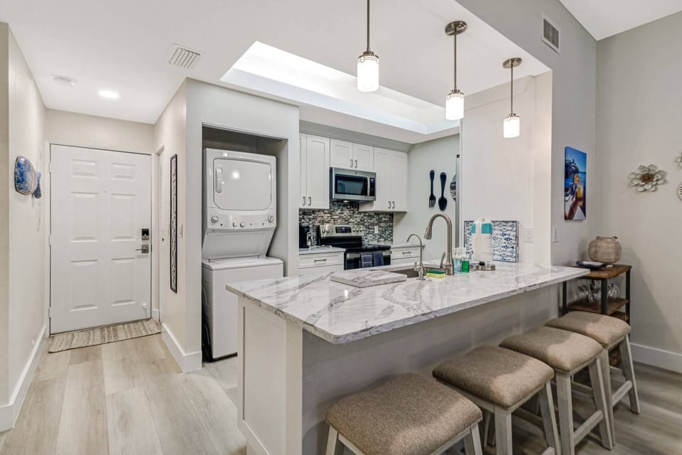 The quartz eating counter offers barstool seating for 4 and divides the open kitchen from the main living space.
