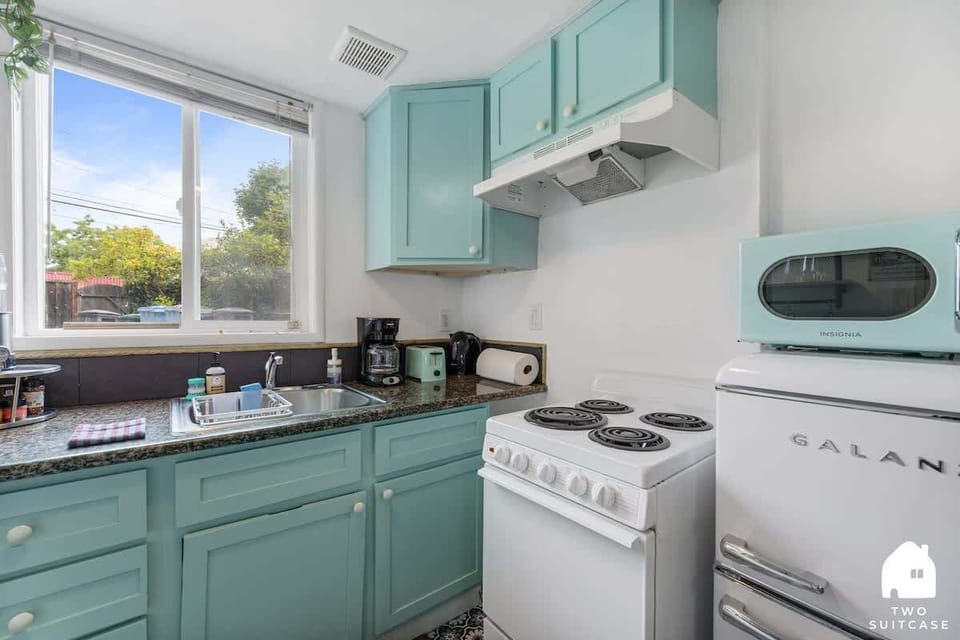 A clean, functional kitchen with mint-green cabinets and all the basics you need for cooking.
