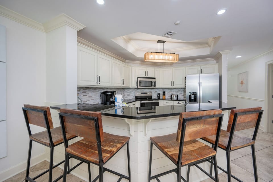 Gather around the cozy bar stools, enjoying quality conversations while sipping your favorite drinks in this inviting kitchen