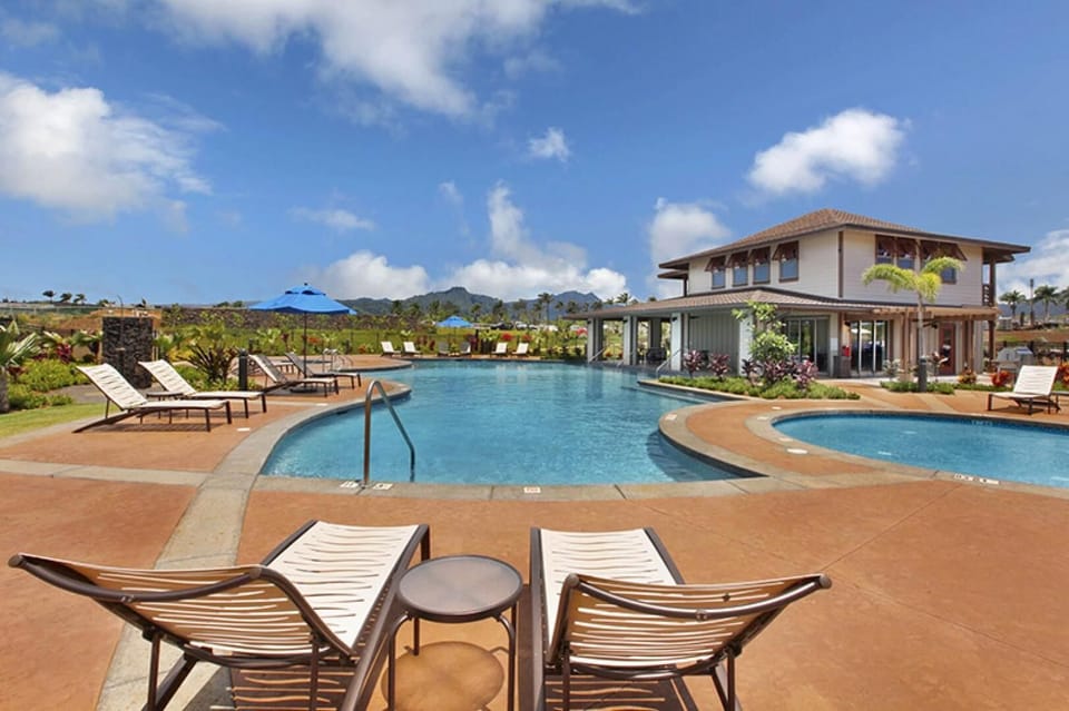 Enjoy resort-style relaxation at the sparkling community pool and hot tub, surrounded by lush landscaping and mountain views. Perfect for cooling off after a day at Poipu Beach.