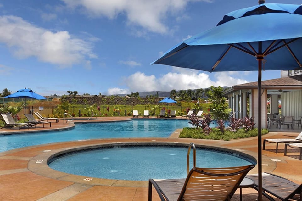 Relax and soak in the inviting community hot tub, surrounded by tropical landscaping and open skies.