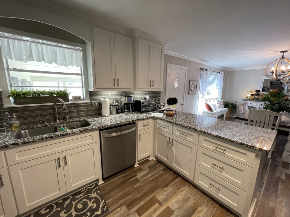 Newly remodeled and fully stocked kitchen plus amenities overlooks dining area. 