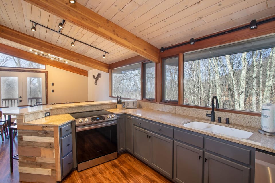 Primary Kitchen with Wall of Windows above Granite Countertops