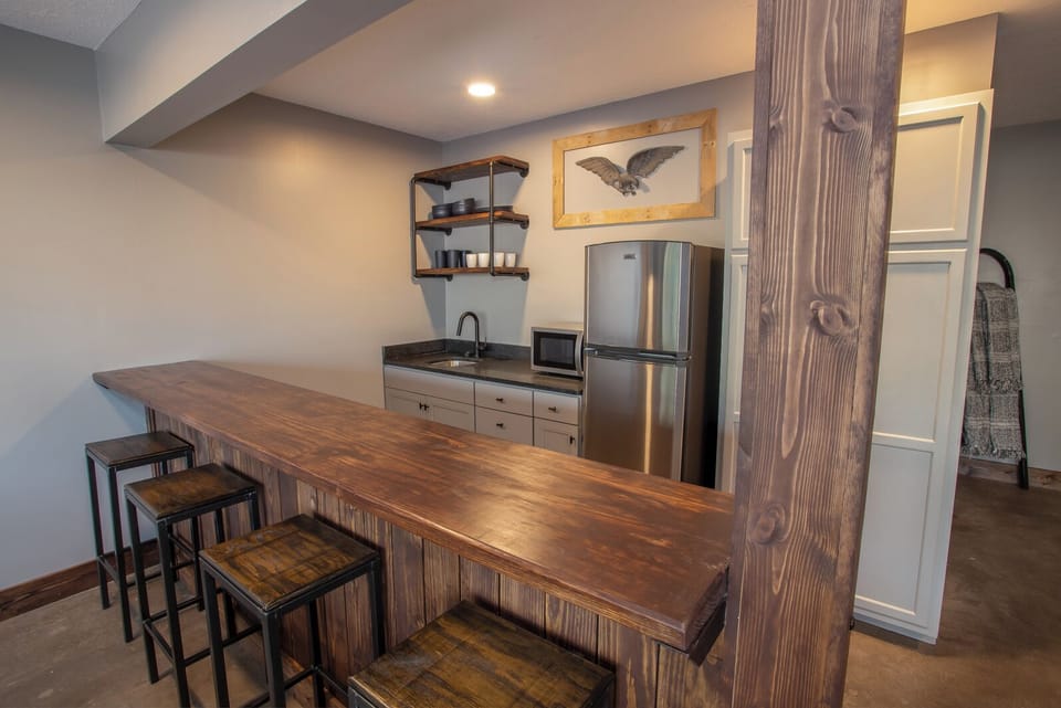 Bar with Sink, Fridge and Freezer, Microwave, and Bar Stool Seating in Indoor/Outdoor Den