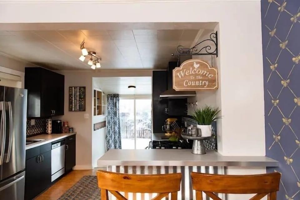 A large kitchen with extra bar seating to sit and chat with the cook as they prepare a home cooked meal.