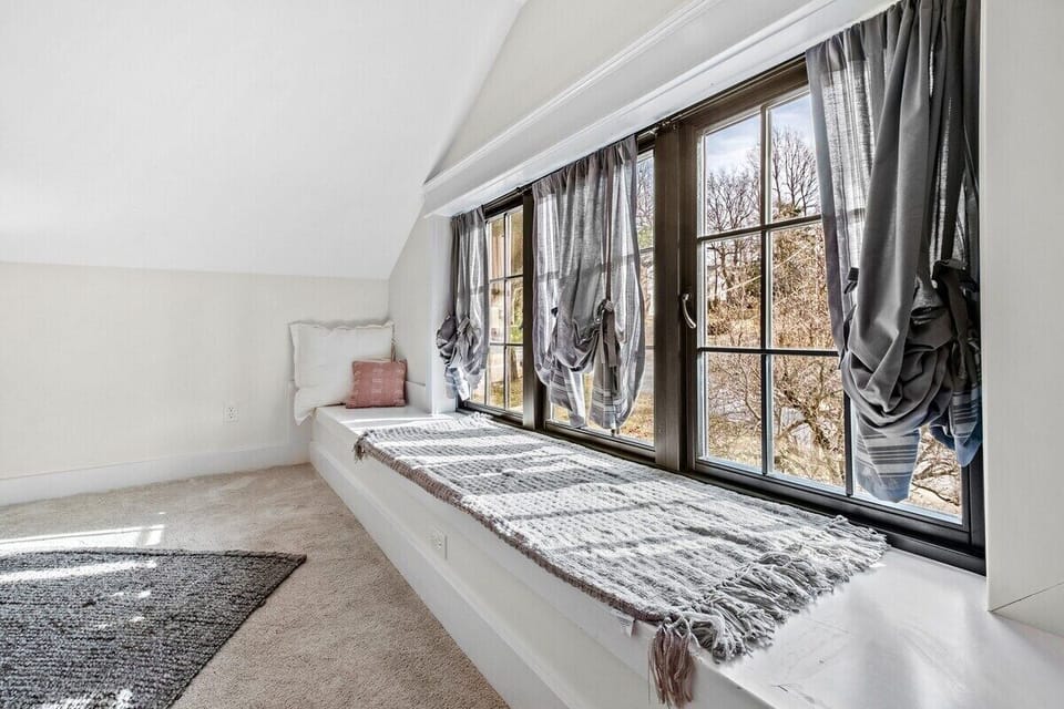 Our fifth bedroom has a King bed, window seat, closet, Smart TV, and en suite bathroom.