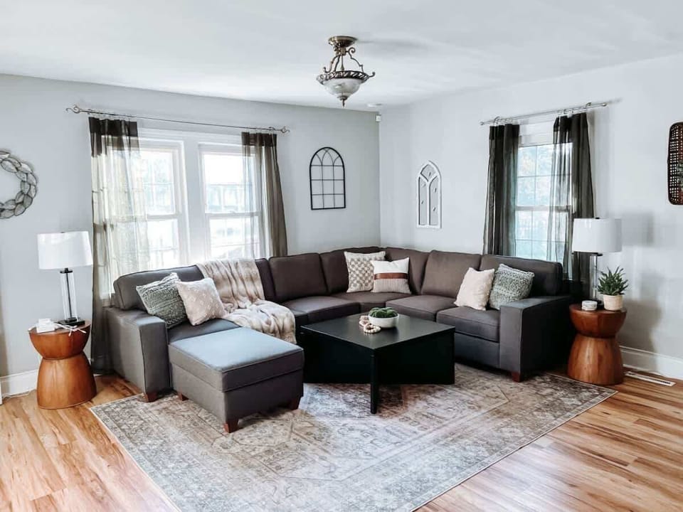 - Spacious living room with sectional sofa and cozy decor   - Large windows with natural light and modern wall art   - Relax in comfort with family seating and smart TV  