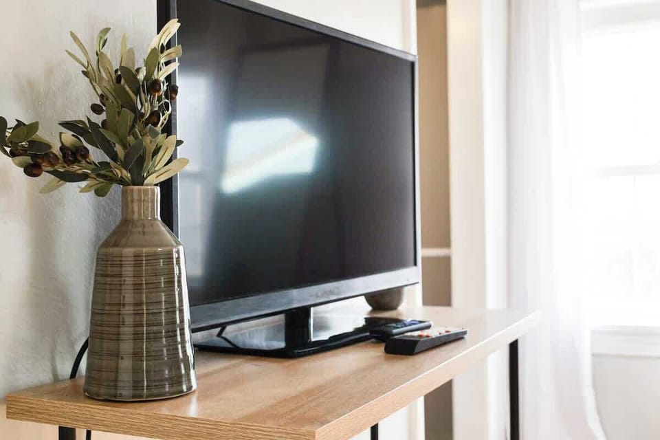 - Flat screen smart TV with streaming access for your favorite shows   - Stylish decor accents including modern vases and greenery   - Entertainment setup perfect for relaxing nights in  