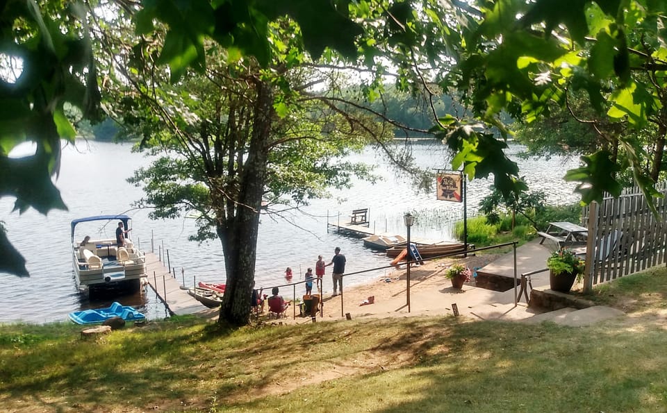 Small beach, with part of boat dock area and "martini deck" with beach chairs.