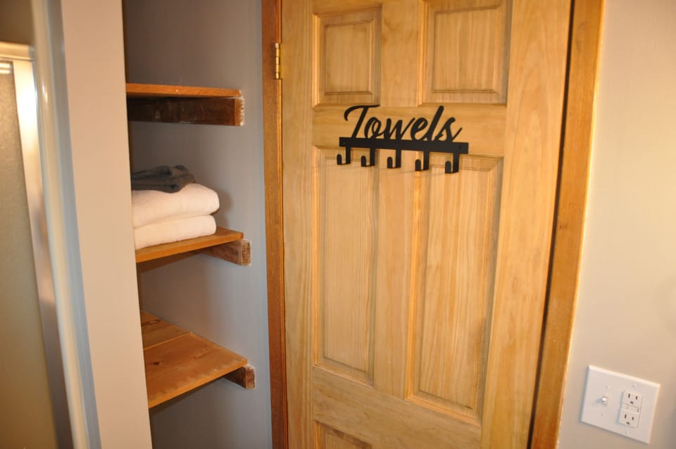 Upper level full bathroom with shower and extra storage.