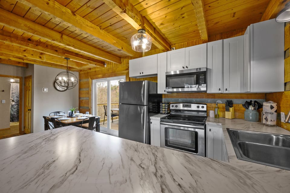 View of kitchen/dining areas and rear deck from breakfast bar.