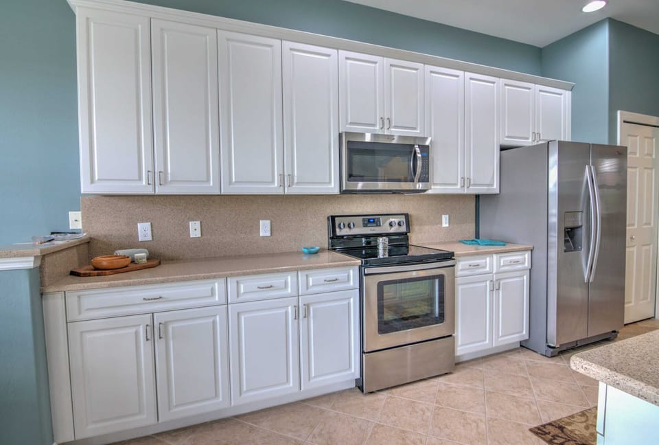 The Kitchen Has Stainless Steel Appliances, Quartz Counters and White Cabinets