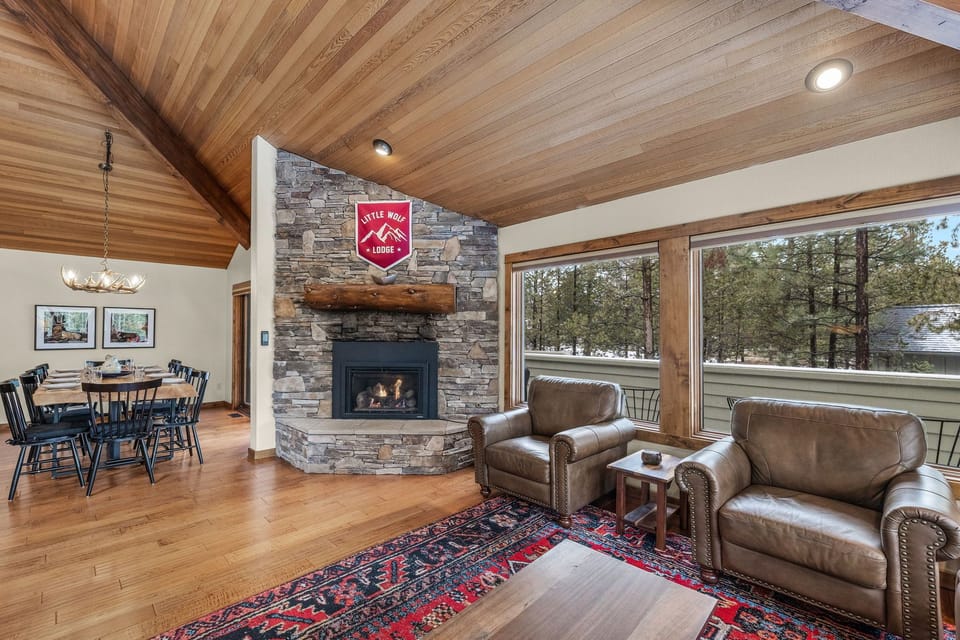 Cozy up in your mountain retreat with soaring wood ceilings, crackling stone fireplace, and forest views through expansive windows.