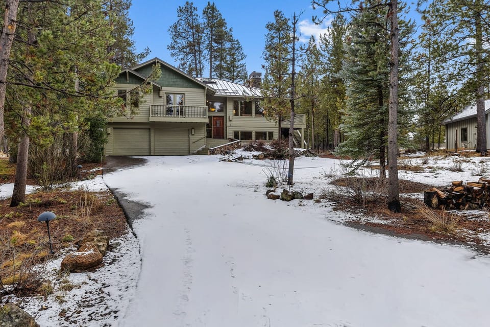 Mountain retreat nestled among towering pines with snow-dusted grounds and peaceful forest surroundings.