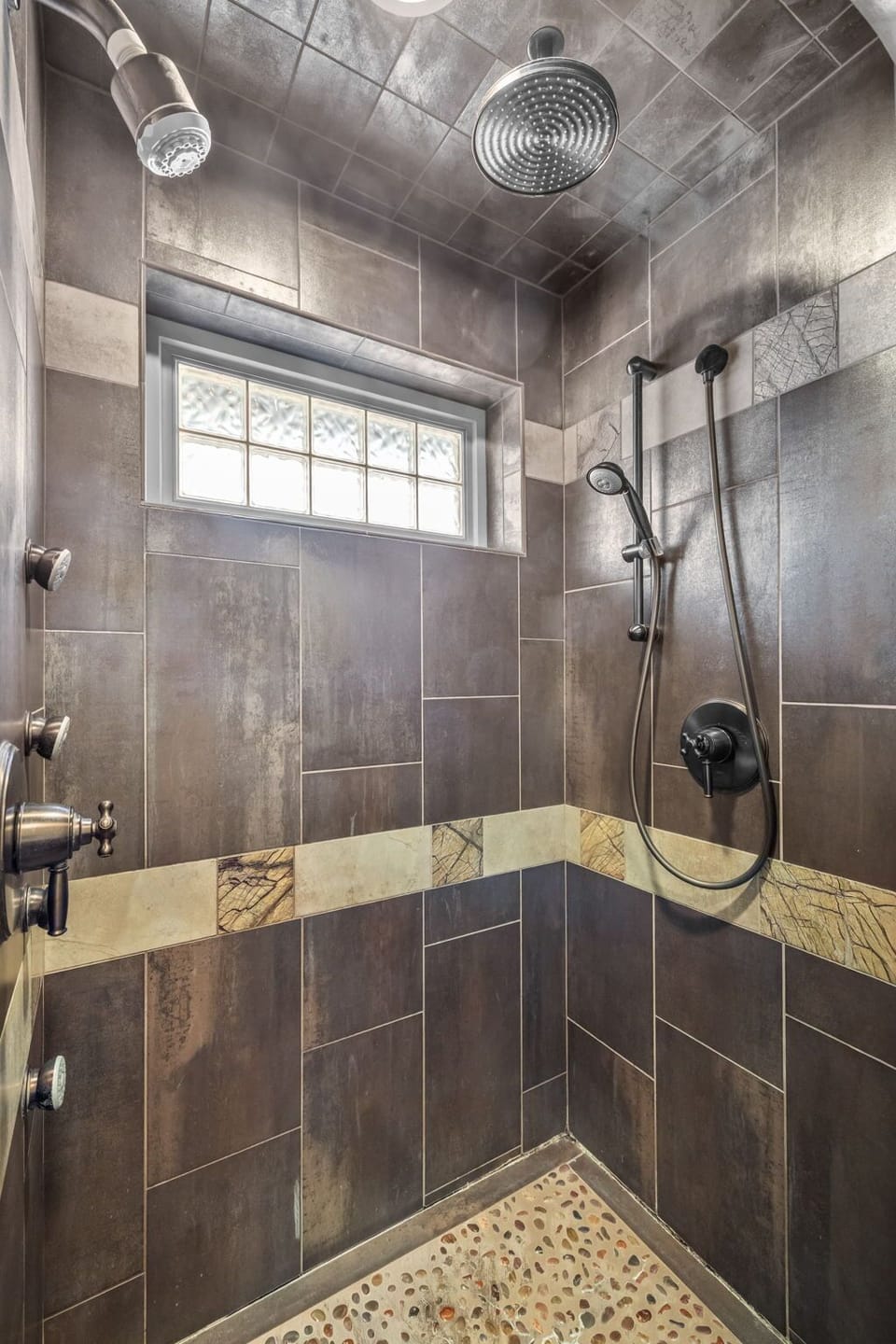 Step into your luxurious tiled shower with dual rainfall and handheld showerheads for the ultimate relaxing retreat.