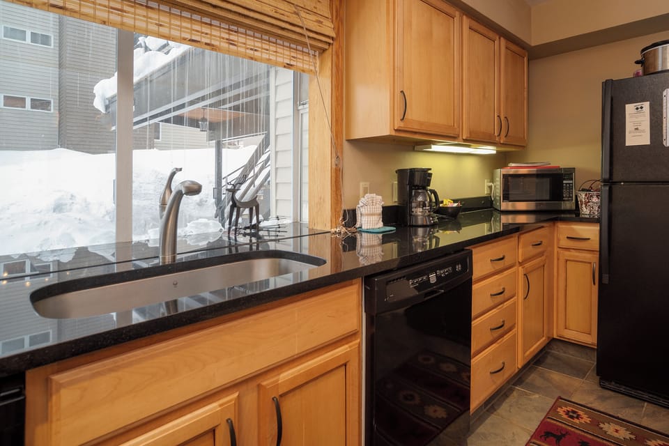 Your fully equipped kitchen features granite counters, modern appliances, and warm wood cabinets—perfect for preparing meals together.