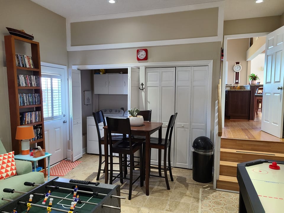 Game room off kitchen with washer/dryer, sleeper sofa, & door to outside