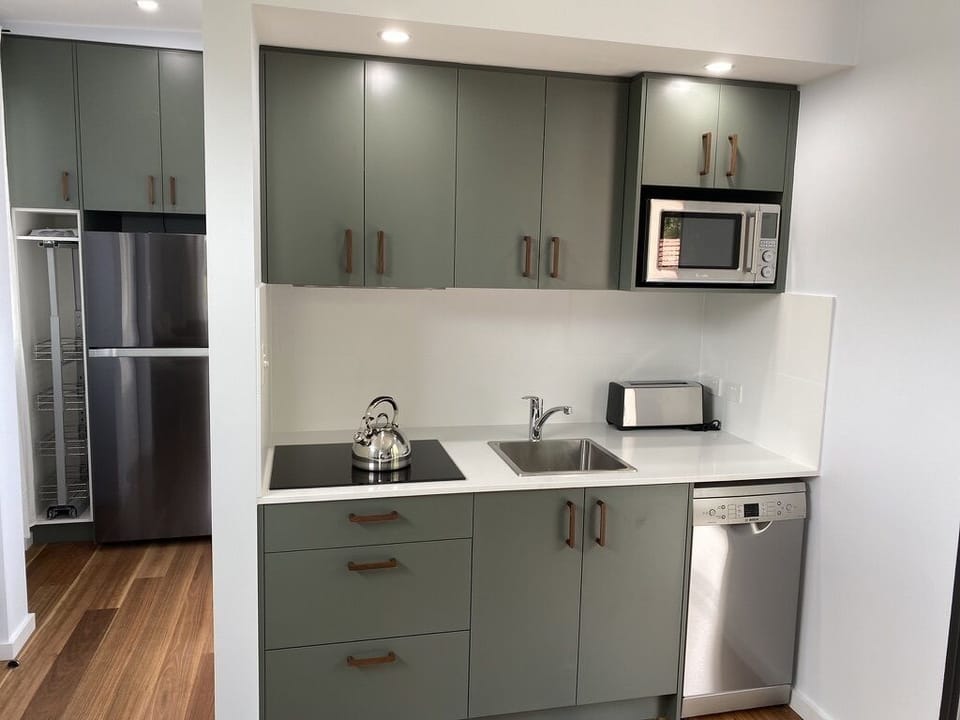 Kitchen with top of the range appliances with full size fridge and cooktop.