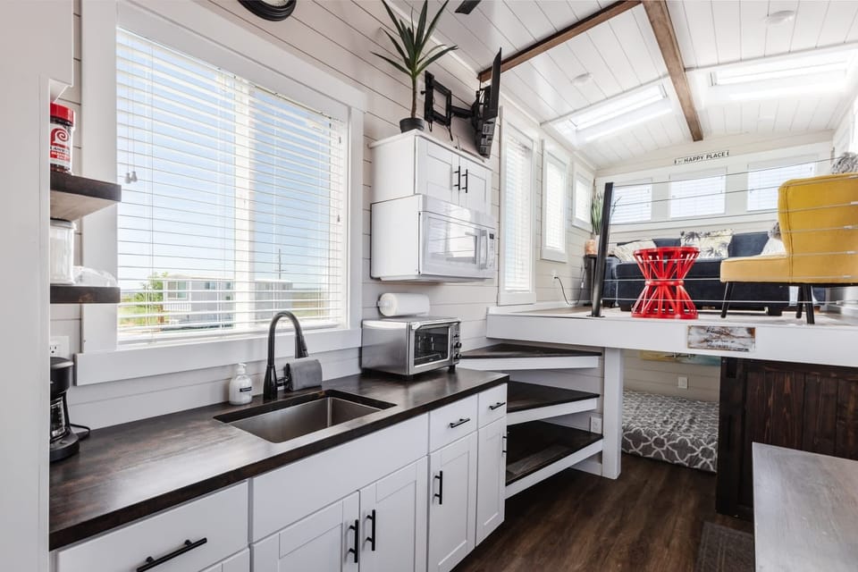 Open kitchen area with modern cabinetry, compact appliances, and easy flow into the living space. Thoughtful layout maximizes function while keeping the kitchen bright and inviting.
