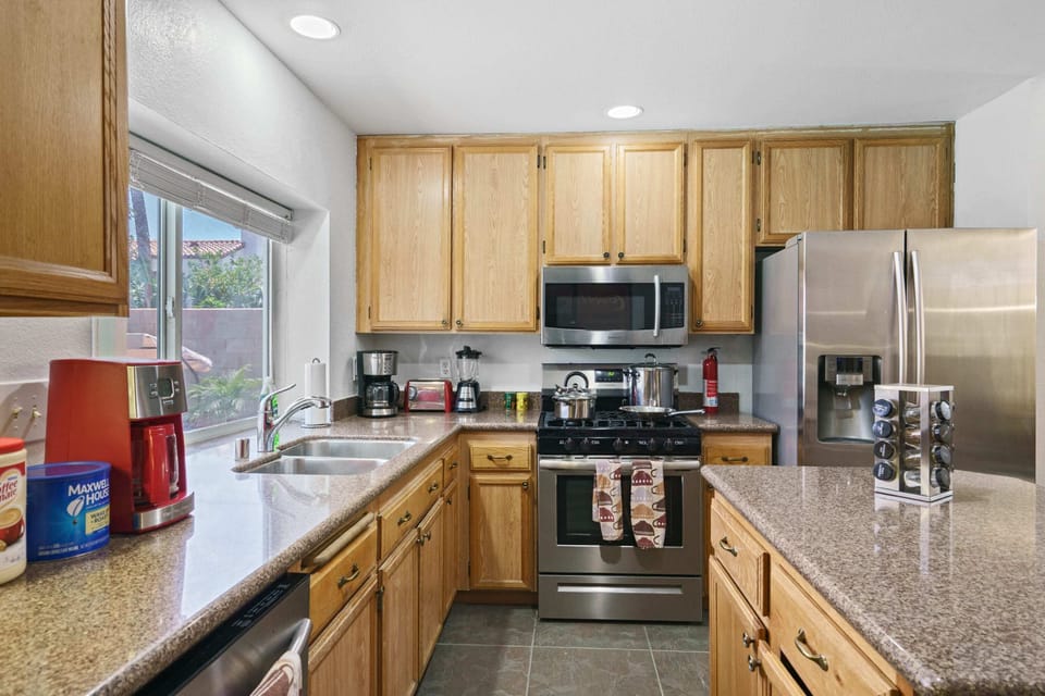 Enjoy the kitchen with coffee, creamers, mixers, refrigerator, oven, stove, pots, pans, cooking supplies, cutlery, cups, plates, bowls, utensils, small appliances, and many essentials!