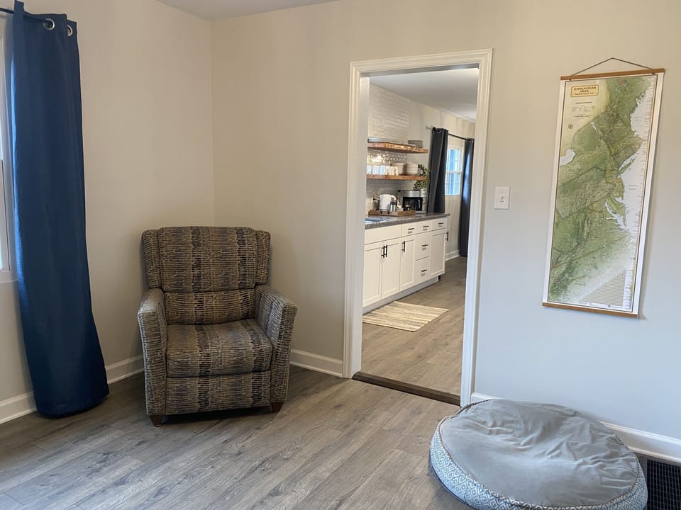 Cozy chair and dog bed in office connecting living room and kitchen