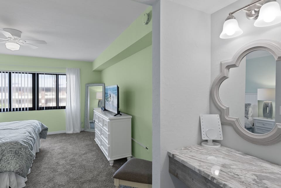 Additional view of the master bedroom with TV and full mirror.