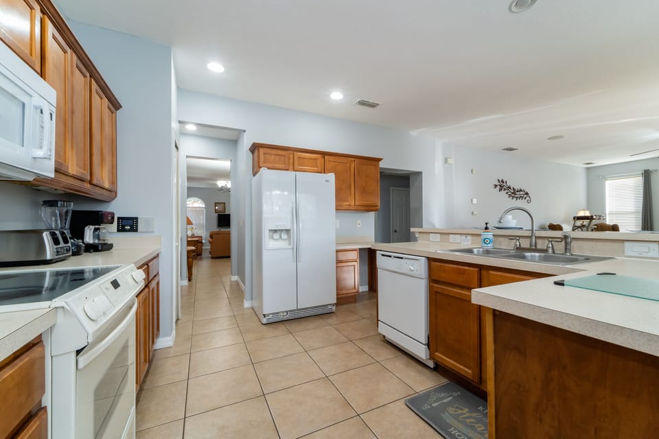 Fully equipped kitchen with ample counter space, full size appliances, and open layout overlooking the living area.