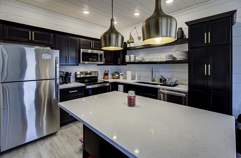 Main floor-fully-stocked kitchen w/stainless steel appliances & bar stools