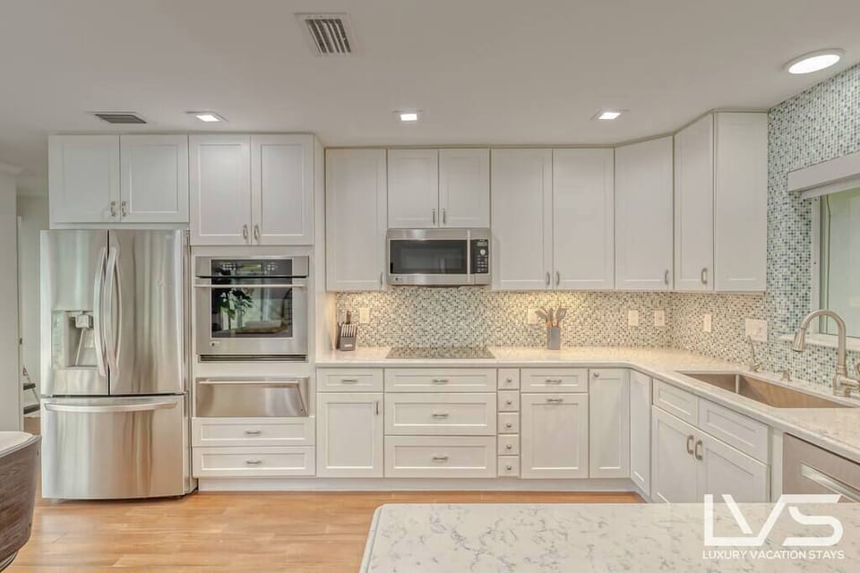Open layout fully appointed eat in kitchen with island for 4, stainless steel refrigerator with filtered water/ice maker, Keurig machine for pod or regular drip coffee, toaster, microwave, filtered water etc.  Look on listing for a detailed list of everything located  inside kitchen. 