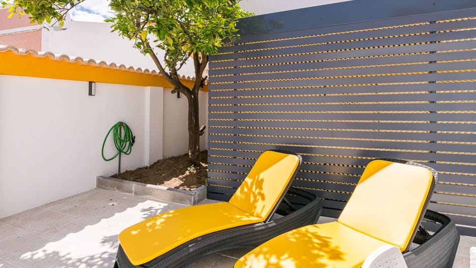 Unwind on the sun-kissed terrace, a secluded outdoor haven shaded by a small tree, ideal for quiet relaxation.
#Terrace #OutdoorSpace #LovelyStay