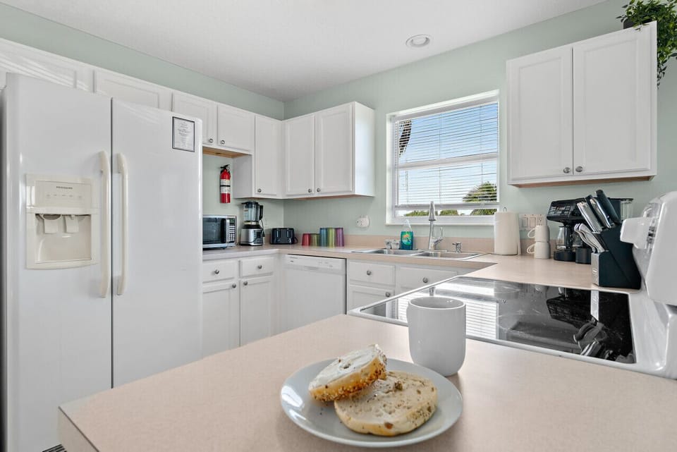 Fully equipped kitchen with flat stove top, refrigerator and freezer, dishwasher, coffee maker and more. (food and coffee not provided)