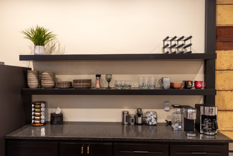 Kitchen w/ drip coffee, Keurig machine, spices, pots, pans and dining utensils.