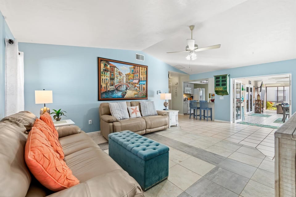 The living room is open to a set of sliders that lead to the pool