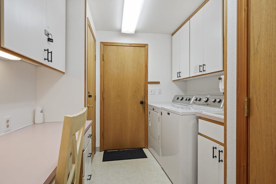 Laundry room with water closet and desk to work from with closing door.