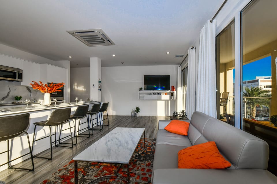 Luxurious living area of the 2BR condo in Noord Aruba - Cosy sofas - Elegantly decored living area - Large bright windows of the living area with Mesmerizing views - Beautifully furnished floor - Availability of TV and Netflix