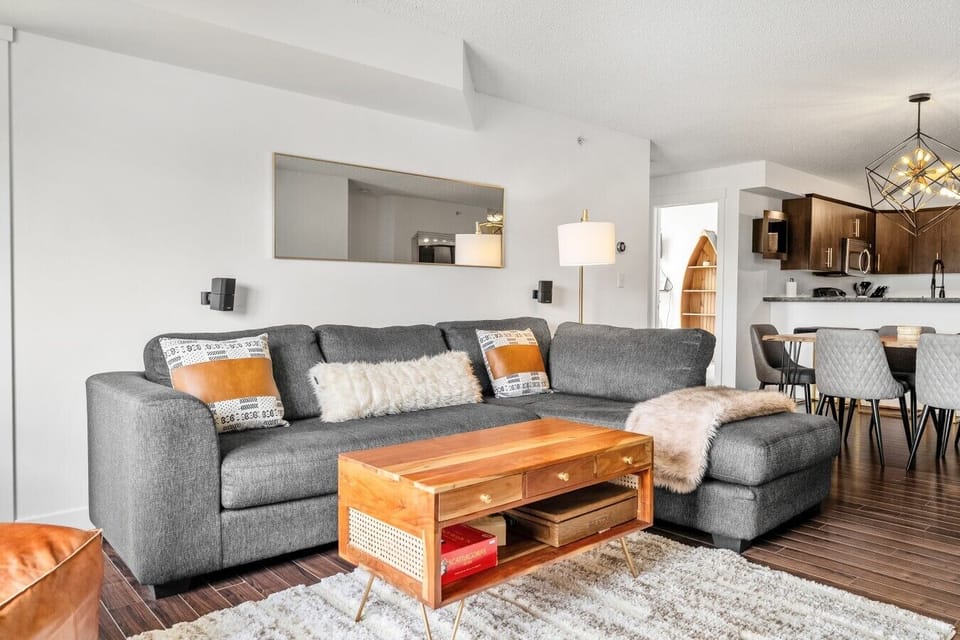 Living room with a large Smart TV, cozy seating options and access to the main private balcony.