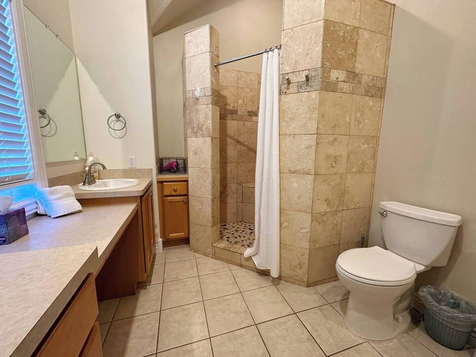 The upstairs bathroom has a large vanity, a walk-in shower, and plenty of storage place.