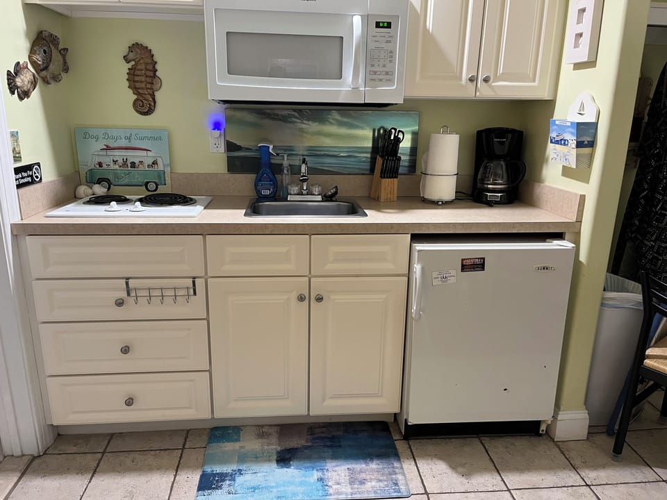 Kitchenette includes plenty of plates, cups, silverware, pans & pots.