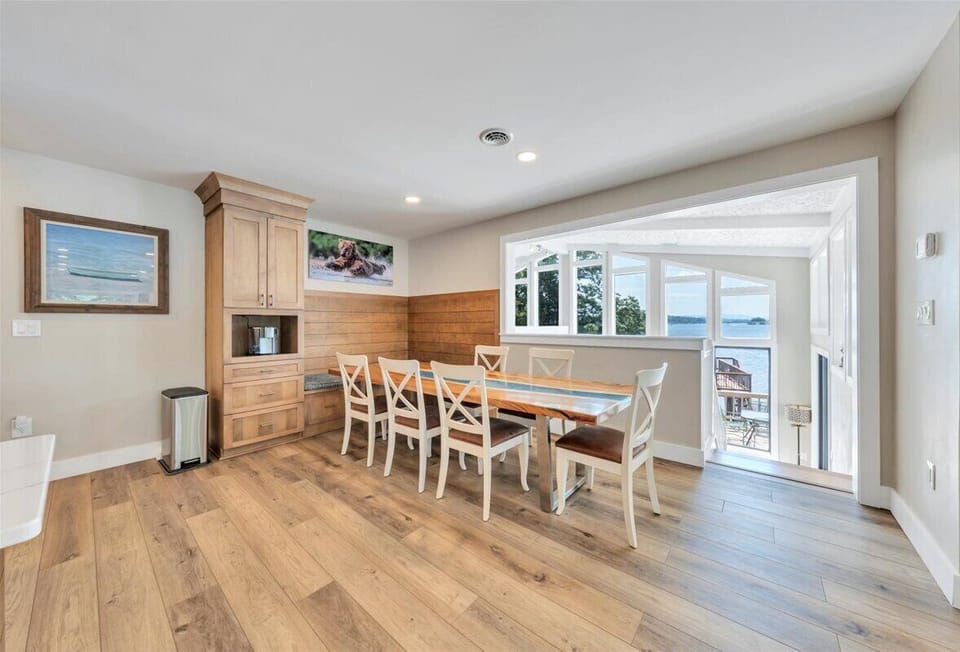 Kitchen overlooks wall of windows in family room